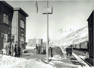Bjørnfjell mai 1945. Fra høyre: svenske tollere, sovjetiske krigsfanger, og tyske offiserer som betrakter det norske flagget